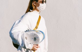 woman in a mask holing toilet paper