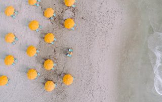 Yellow beach umbrellas with blue beach chairs on a beach